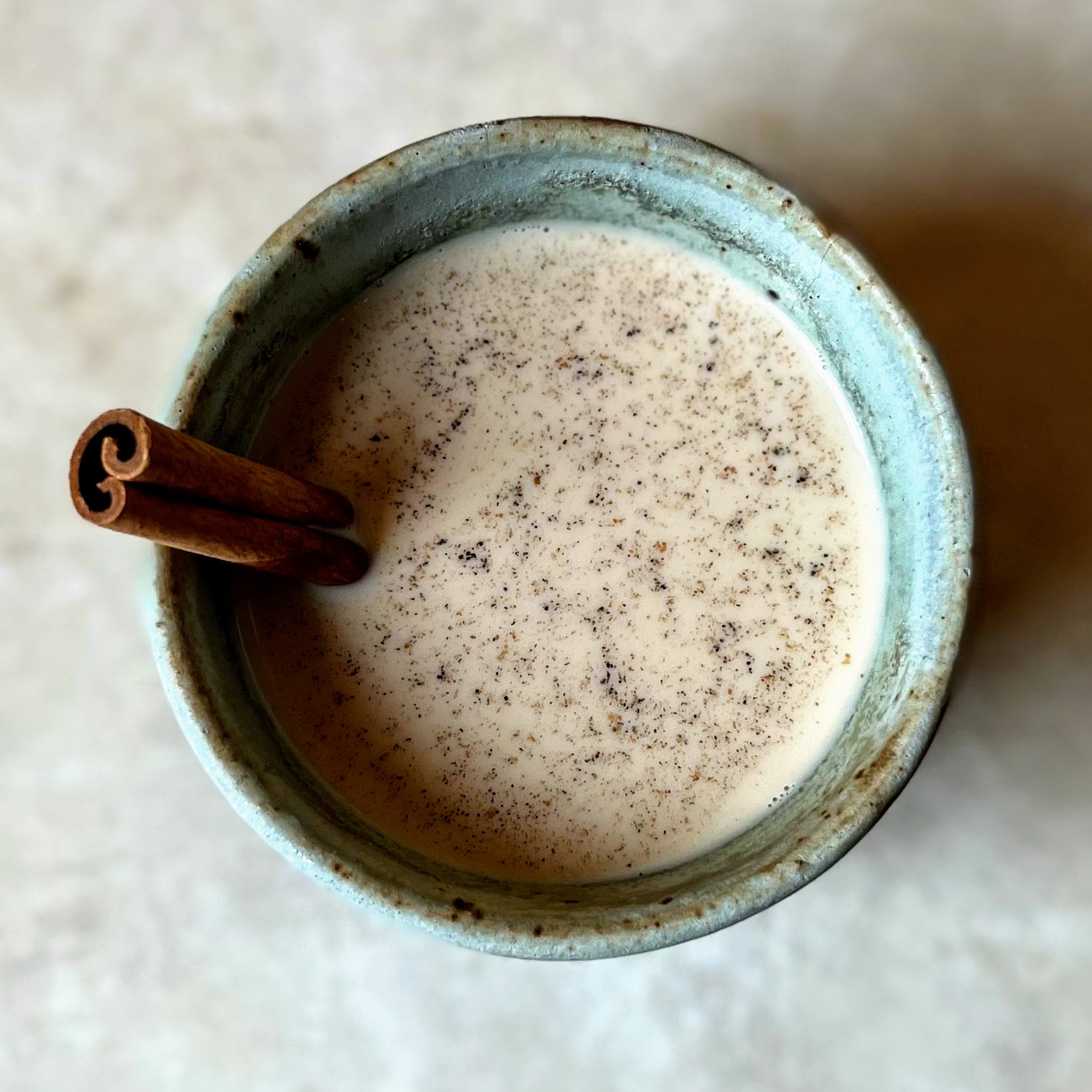 A cup of chai, garnished with a cinnamon stick.